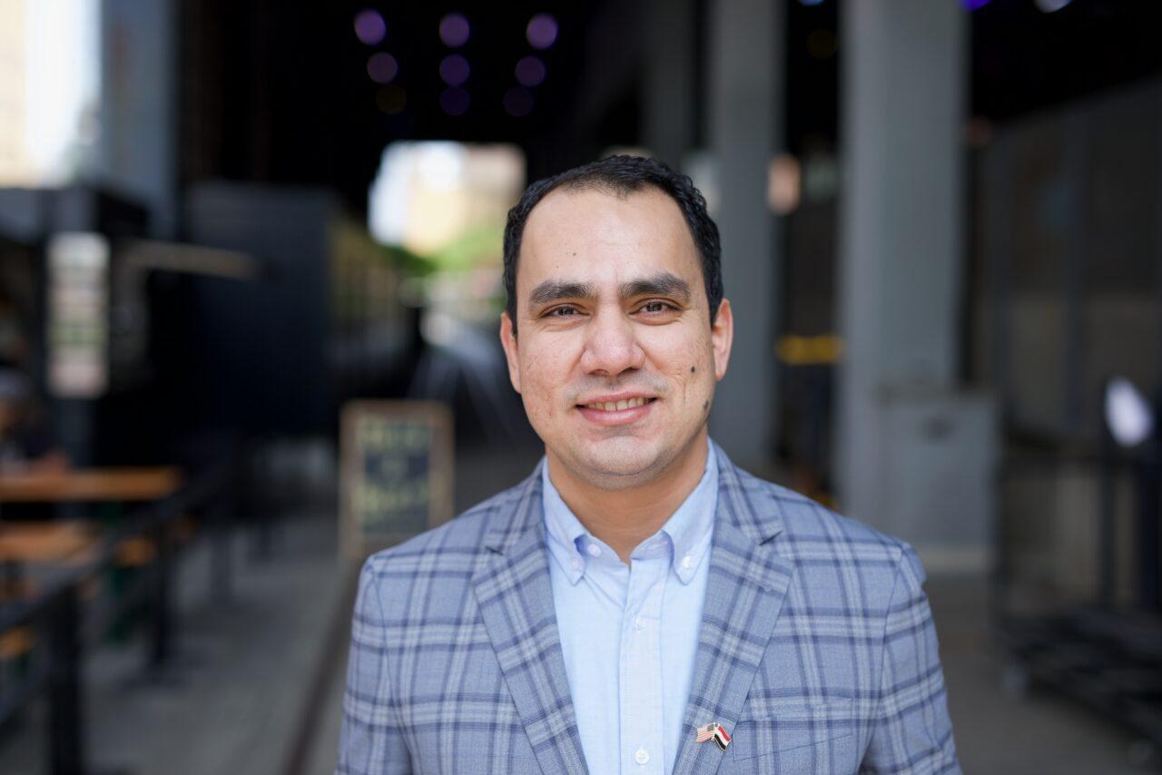 Portrait of Faisal Saeed Al Mutar in a blue plaid jacket, smiling